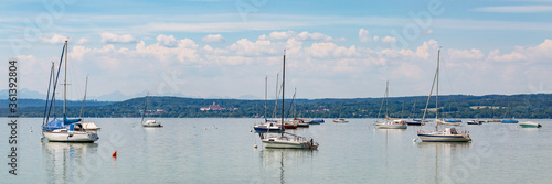 Anchoring sailboats at Lake Ammersee. Marienmuenster Diessen at the horizon.