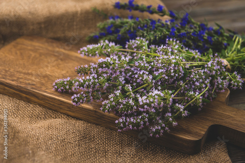 Bunches of medicinal herbs with purple and blue flowers copy space. Thyme and hyssop flowers on a wooden table. photo