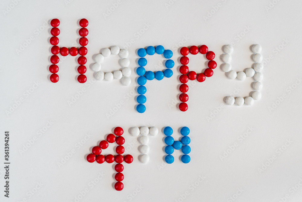 Patriotic colored red, white and blue button-shaped chocolates spelling out 'Happy 4th' on a white background. Ideal for America's Holiday, Fourth of July Independence Day Patriotic colored red, white and blue button-shaped chocolates spelling out 'Happy 4th' on a white background. Ideal for America's Holiday, Fourth of July Independence Day