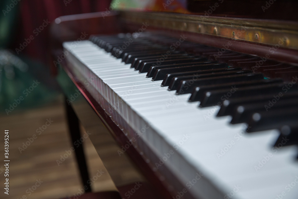 piano presses . Piano keys close up. Musical instrument . Select focus and soft focus.Close-up of a wooden piano . Defocused classic piano keyboard in white and brown colors . piano presses . Piano keys close up. Musical instrument . Select focus and soft focus.Close-up of a wooden piano . Defocused classic piano keyboard in white and brown colors .