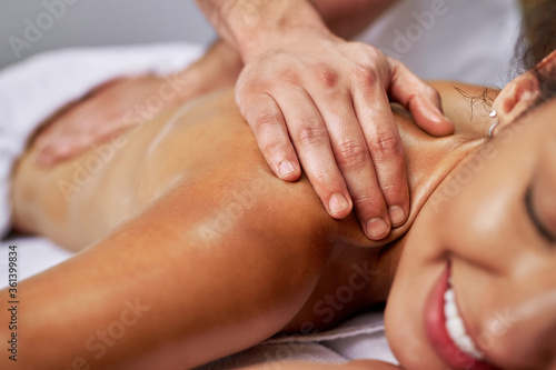Close-up of a woman enjoying in back massage at the spa.
