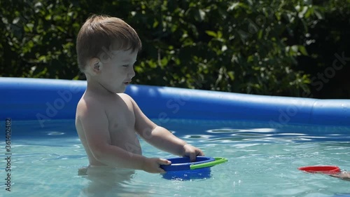 Mom and son play in the outdoor pool in summer