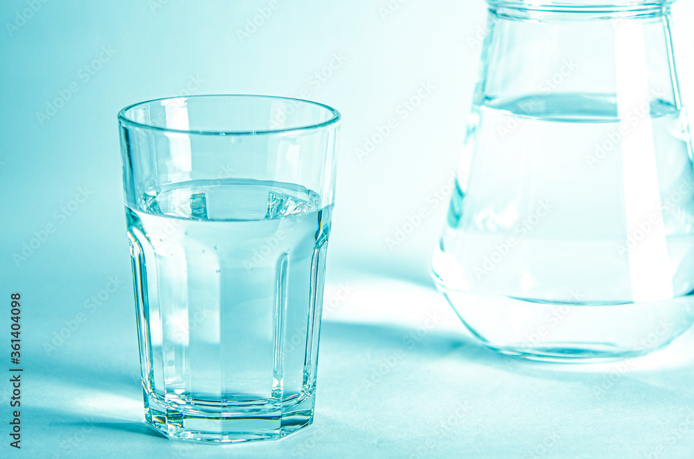 Glass with pure clear melt water on a blue background Glass with pure clear melt water on a blue background