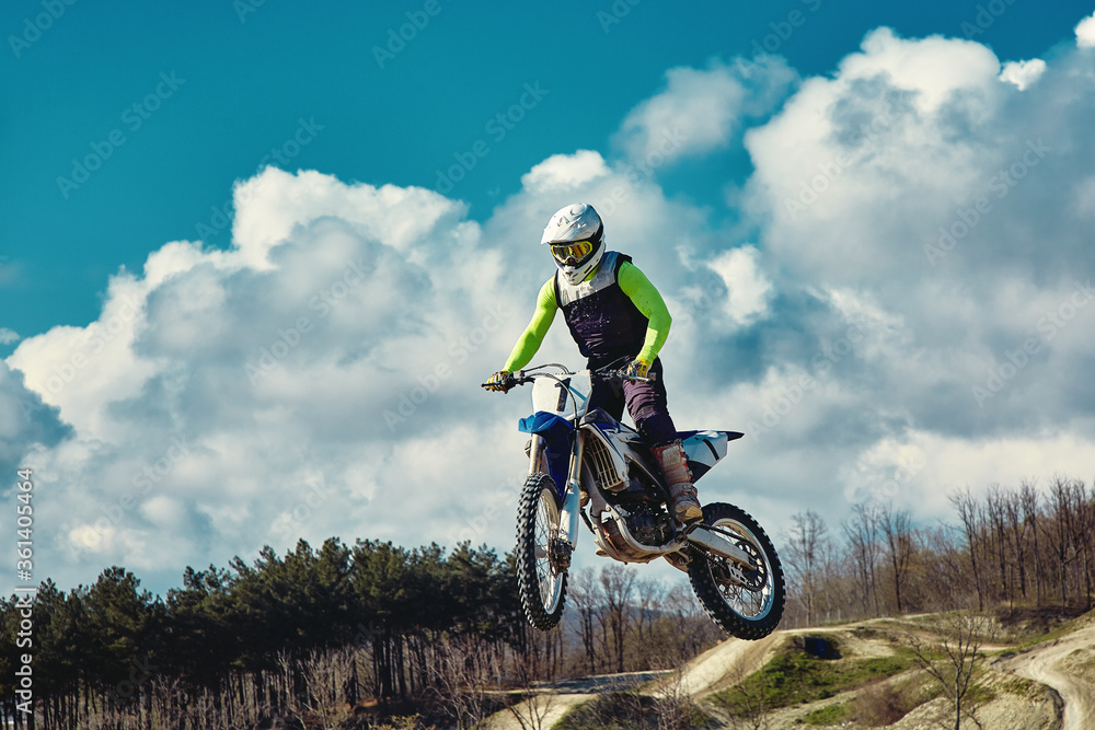 Extreme concept, challenge yourself. Extreme jump on a motorcycle on a background of blue sky with clouds. Copy space, all or nothing. Extreme concept, challenge yourself. Extreme jump on a motorcycle on a background of blue sky with clouds. Copy space, all or nothing.