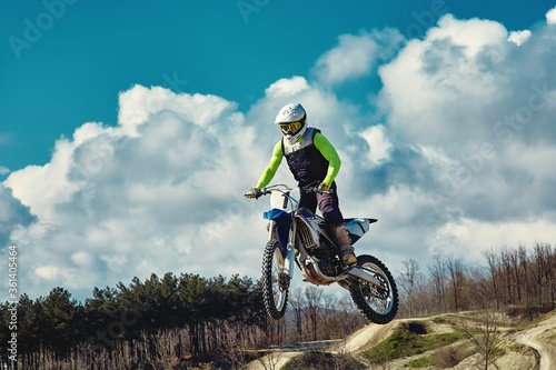 Extreme concept, challenge yourself. Extreme jump on a motorcycle on a background of blue sky with clouds. Copy space, all or nothing.