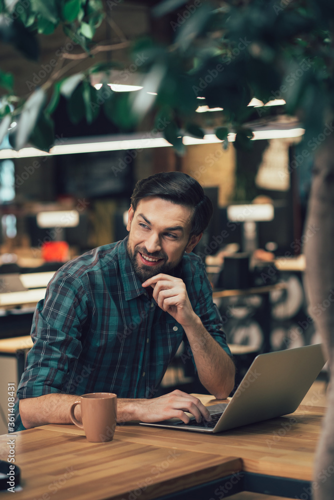 Positive office worker with modern gadget at the table alone Positive office worker with modern gadget at the table alone