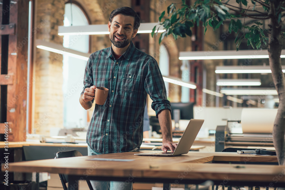 Happy employee with modern gadget and tasty coffee Happy employee with modern gadget and tasty coffee