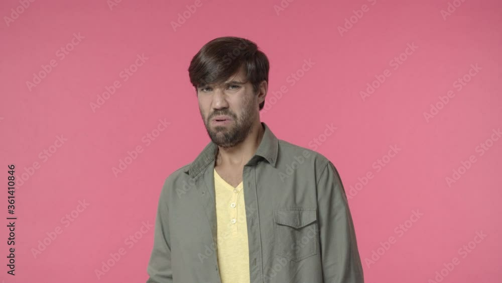 Man seeing disgusting thing. Handsome hispanic, bearded guy cringe, grimacing from aversion and dislike, pulling shocked startled face, look at embarrassing thing with discomfort, pink background Man seeing disgusting thing. Handsome hispanic, bearded guy cringe, grimacing from aversion and dislike, pulling shocked startled face, look at embarrassing thing with discomfort, pink background