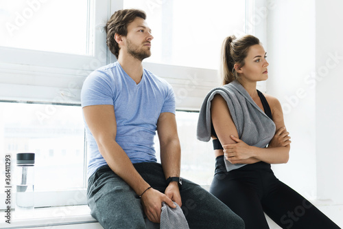 Man and woman resting after workout in the gym