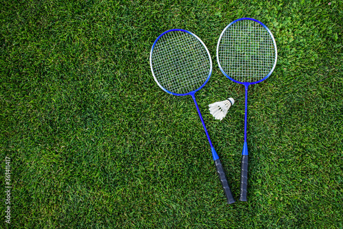 Rackets and a shuttlecock for badminton on the grass.Top view. Concept of summer hobby, outdoor sports, entertainment