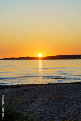 Beach sunset over sea with reflection in the water at Skalderviken, Angelholm, Sweden. photo