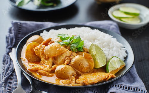 thai massaman curry on plate with jasmine rice and lime wedge