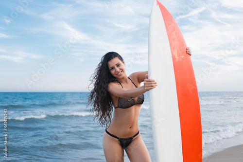 Photography Portrait of a smiling Latin woman posing on sea shore after surfing during the s