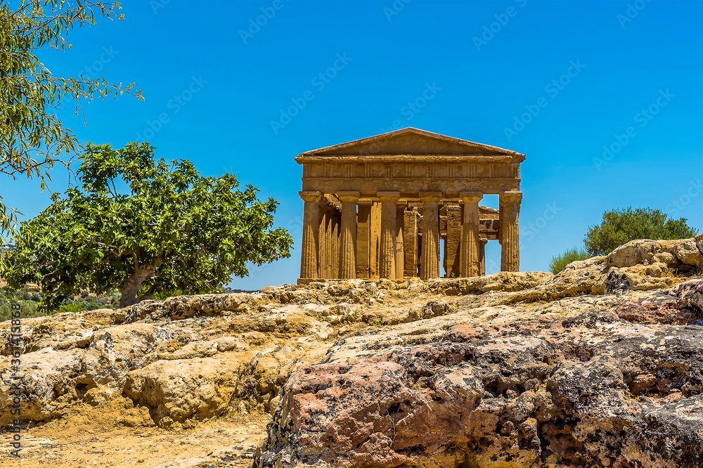 The Temple of Concordia with a rocky outcrop in the foreground in the ancient Sicilian city of Agrigento in summer