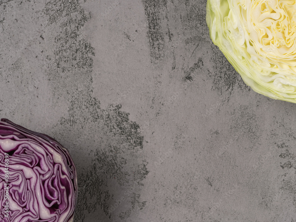 Obraz premium Organic white cabbage and red cabbage in cross section. The gray background.