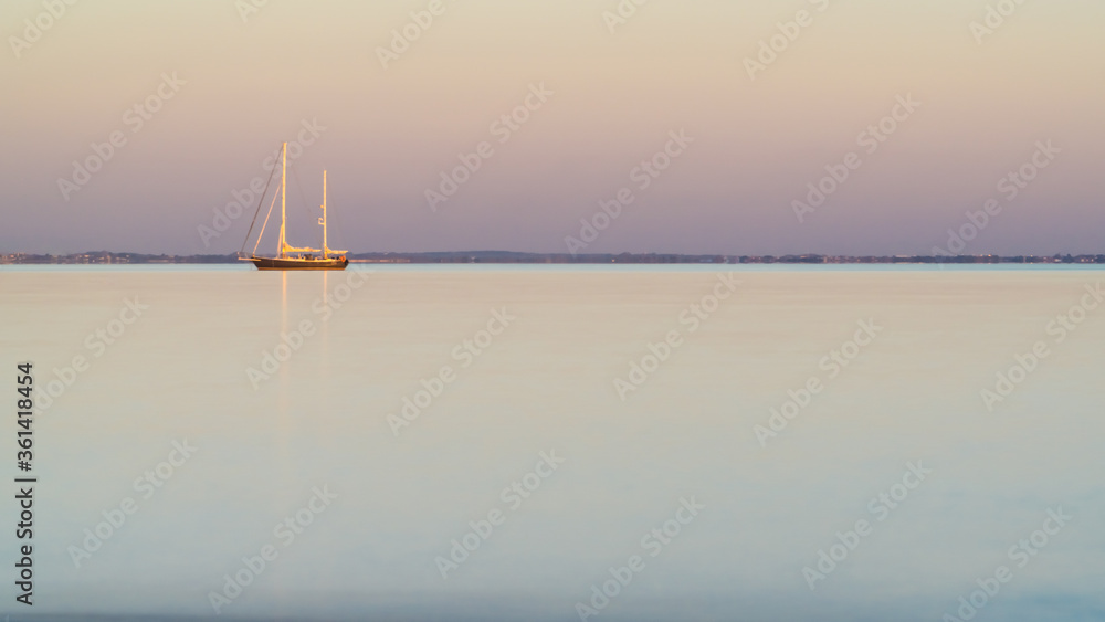 sailing boat, isle of Re, at sunset on a very calm sea