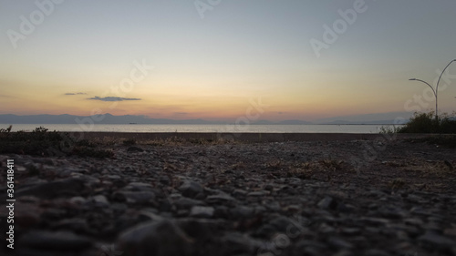 Rocks and the sunset view on the horizon. © Mert G.