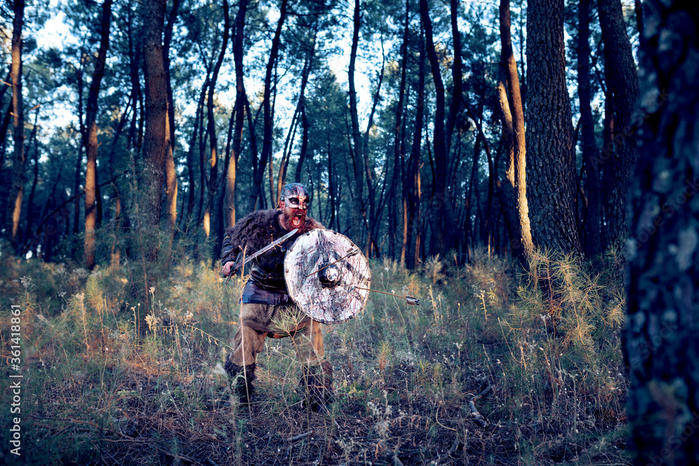 Red-bearded Viking in suit and blood-filled leather armor from a battle in the middle of the forest Red-bearded Viking in suit and blood-filled leather armor from a battle in the middle of the forest