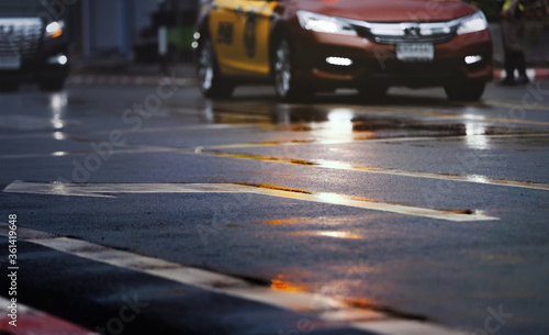 Wet road in the city with light reflections,twilight scene after hard rain fall. View from the level of asphalt.