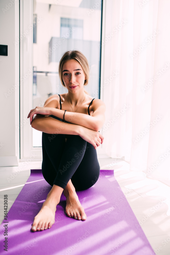 Attractive young woman taking a break while exercising at home. Attractive young woman taking a break while exercising at home.