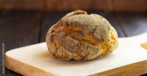 small homemade bread, biscuit called Broa or broinha, bread made from corn, on a rustic wooden background.