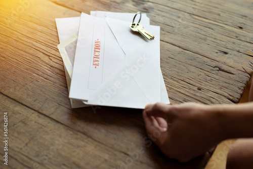 Hands of a female holds an eviction notice - Broke - Laid off from work - Losing home photo