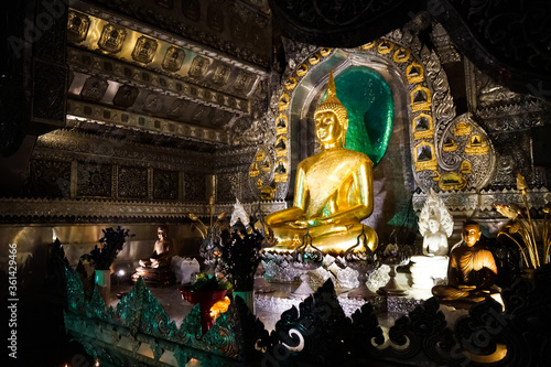 Chiang Mai, Thailand — 1 july 2020, Temple Wat Si Supan at night, curly silver bas-reliefs and a golden buddha                                                           photo