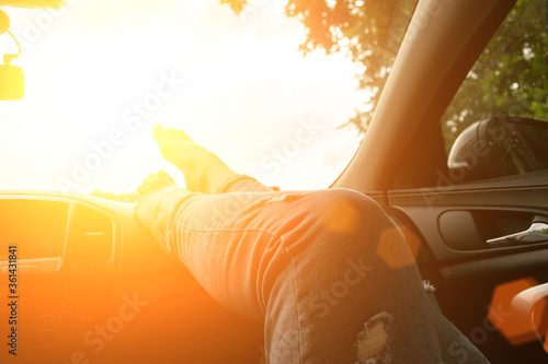 Fototapeta Naklejka Na Ścianę i Meble -  Travel car trip on road at sunset. Happy young woman have fun driving inside vehicle in summer sunny day. Driver ride vacation concept.