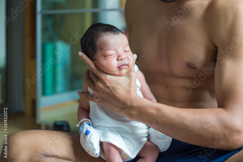 Fotografi Beautiful young Asian father hold newborn baby boy with hand to help baby belch