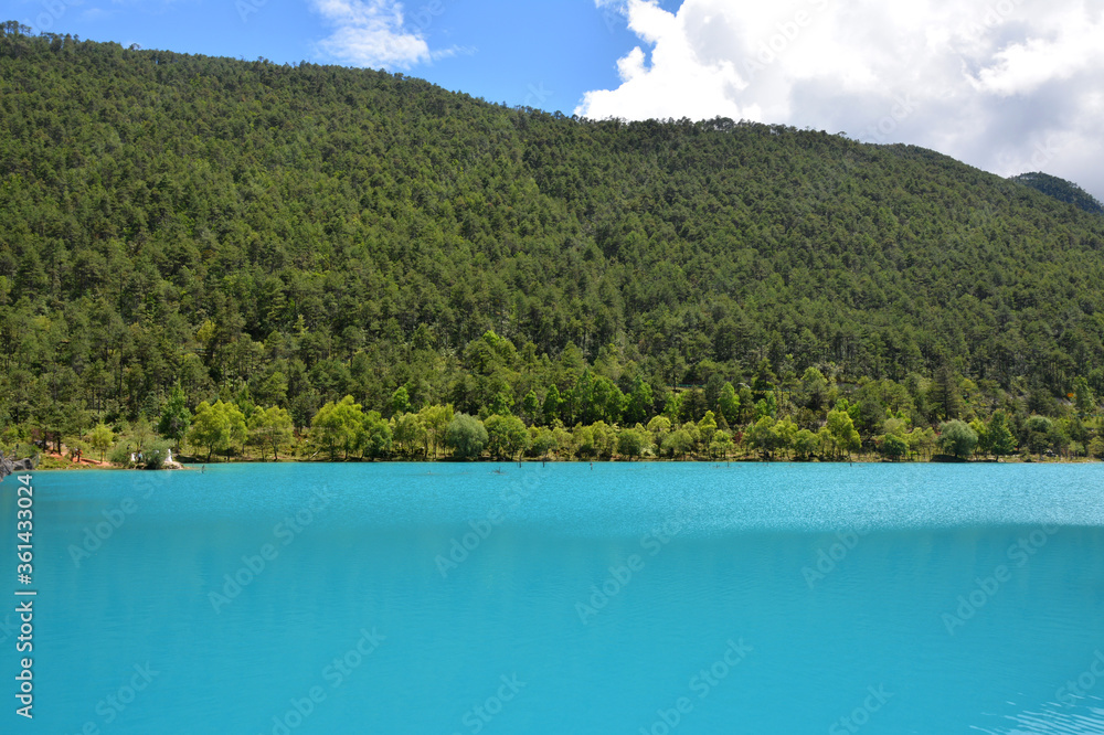 blue lake and green mountain under the blue sky with white clouds