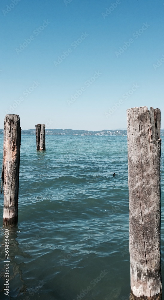 a wooden pier between the lake and the sea a wooden pier between the lake and the sea
