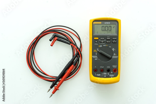 Yellow Digital multimeter with probes for measuring voltage, current, resistance on white background , A multimeter is an electronic measuring instrument.	
 photo