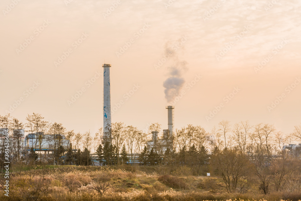 column of smoke rising from tall white smokestack column of smoke rising from tall white smokestack
