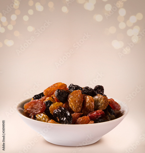 Raisins into a bowl on beige background. photo