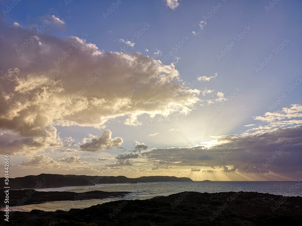 Sun sets behind clouds. Dramatic view of a remote beach on the Western Australian south coast.