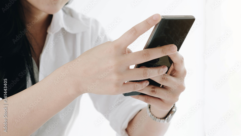 Closeup image of a beautiful Asian woman holding , using and looking at smart phone with feeling happy Closeup image of a beautiful Asian woman holding , using and looking at smart phone with feeling happy