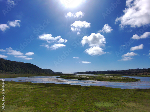 clouds and blue skies over the Batiquitos Lagoon with lush green trees in Carlsbad  California USA photo