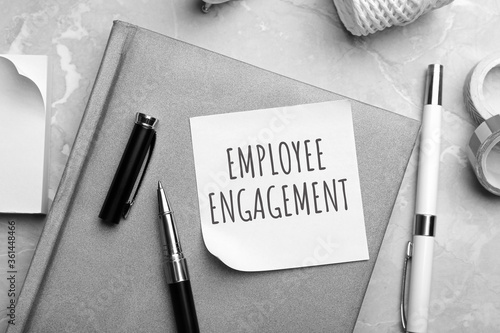 Note with text EMPLOYEE ENGAGEMENT and stationery on table, flat lay