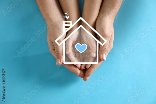Illustration of house and happy family holding hands on blue background, top view