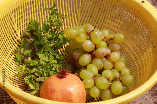 grape pomagranate and mint in yellow basket assorted fruit