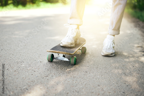 Fototapeta Naklejka Na Ścianę i Meble -  Skateboarding on asphalt, male legs on skateboard sport lifestyle in summer