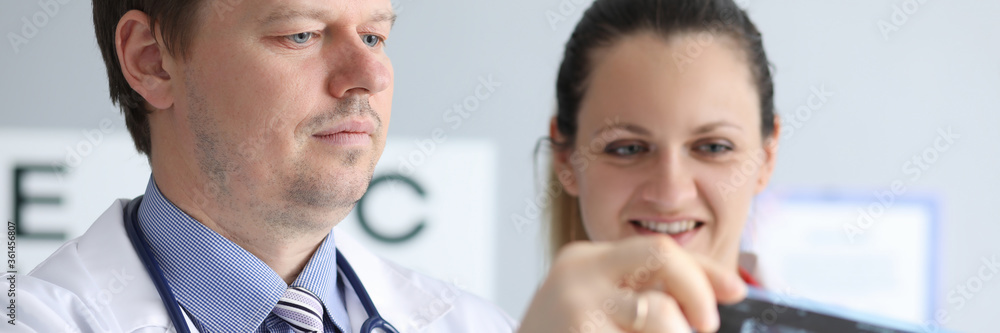 Male and female doctors carefully look at an x-ray. Magnetic laser therapy. Make an appointment with clinic. Success operation depends on knowledge and experience surgeon. Get surgeon consultation Male and female doctors carefully look at an x-ray. Magnetic laser therapy. Make an appointment with clinic. Success operation depends on knowledge and experience surgeon. Get surgeon consultation