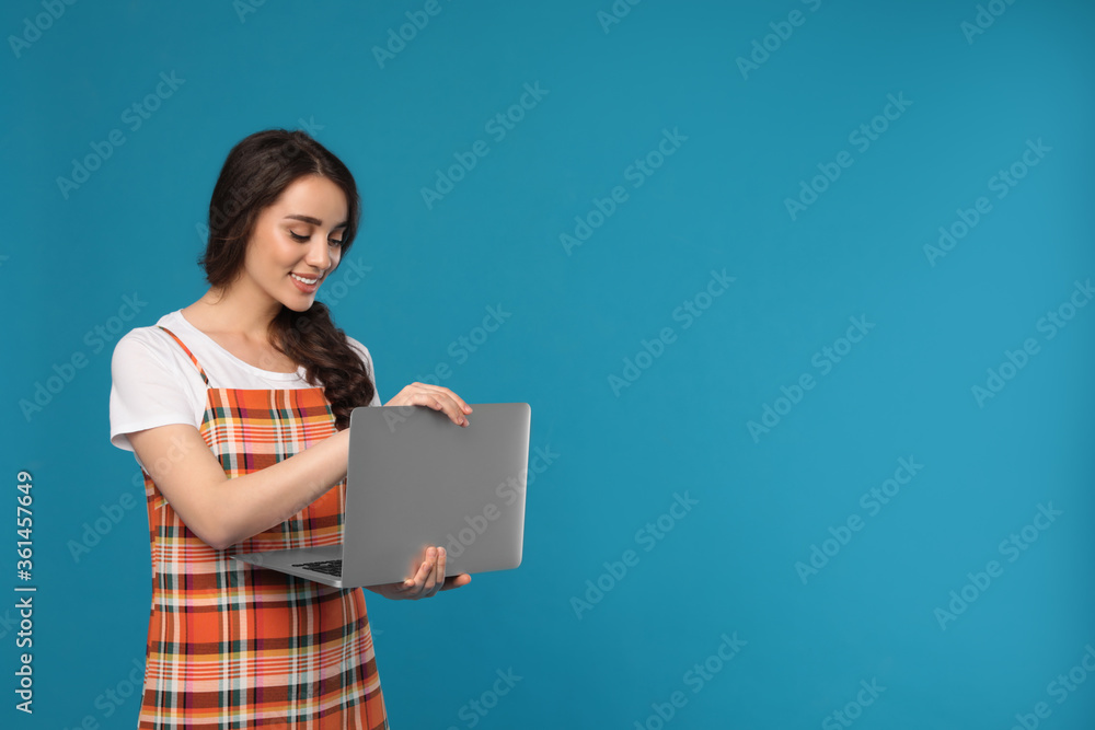 Young woman with laptop on blue background. Space for text Young woman with laptop on blue background. Space for text