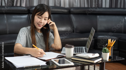 Asian woman working with laptop and document remotely or work from home concept
