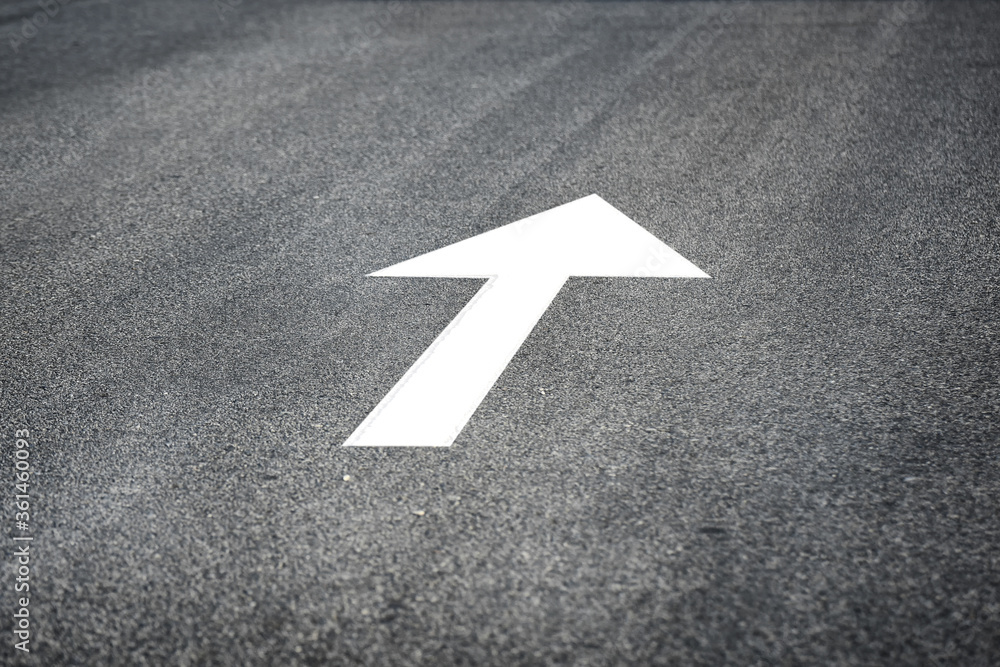 White arrow marking on road surface, transportation concept and business challenge idea White arrow marking on road surface, transportation concept and business challenge idea