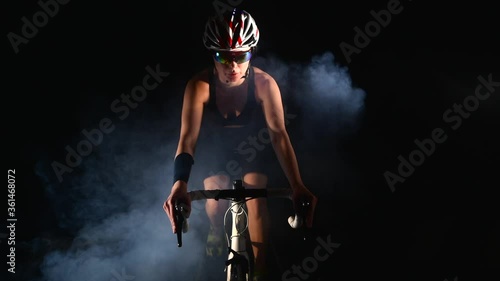 Smiling woman cycling road bike, Pedaling bicycle, sport concept, studio black photo