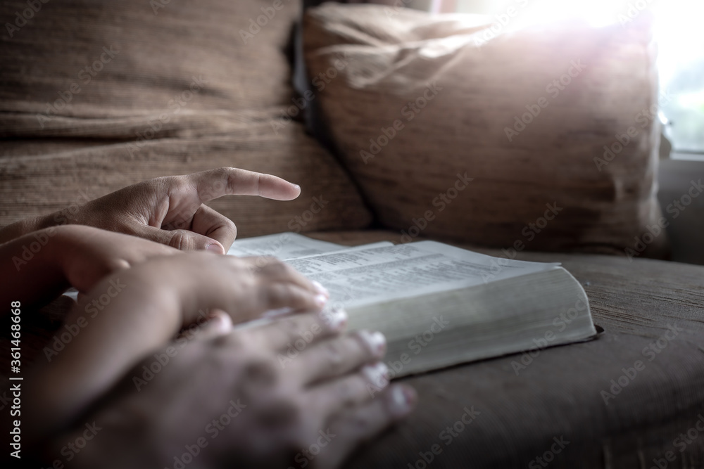 Fototapeta premium Child and father hands reading the Bible, Close up, Christian family concept.