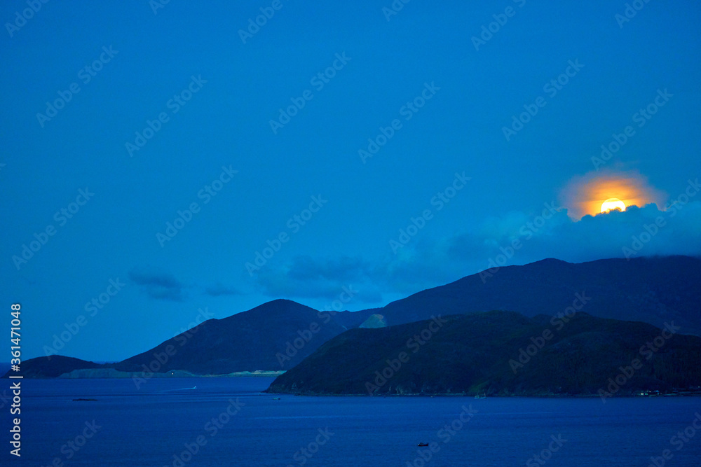 Spectacular moonrise over the tropical island. Calm seascape. Night time.