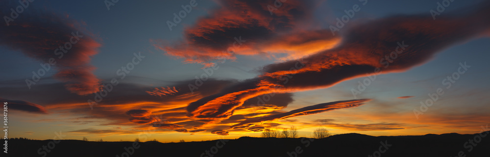 Evening sky with lenticular clouds in red tones, panorama. Evening sky with lenticular clouds in red tones, panorama.