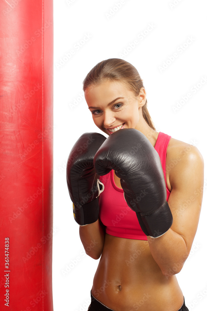 Portrait brunette boxing girl in boxing gloves and body hitting pear